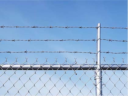 Barbed wire installation on chain link fences