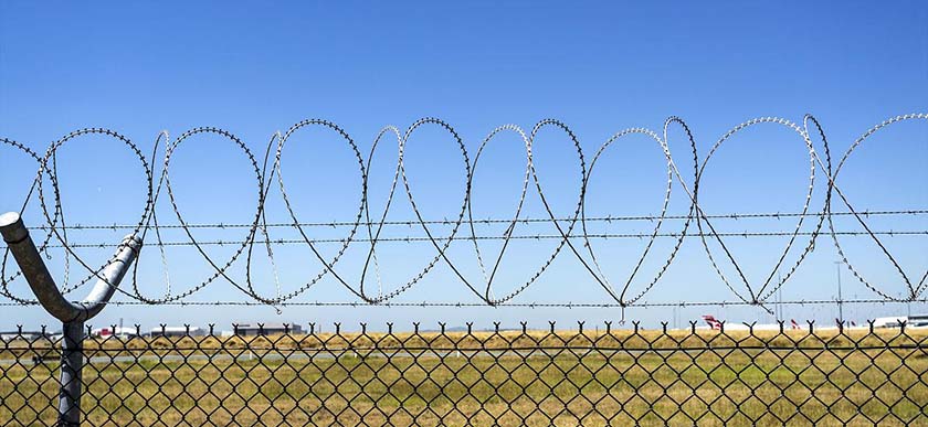 Concertina razor barbed wire installed on top of chain link fence